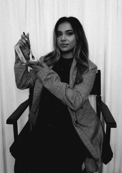 Misha holding a makeup palette and brush